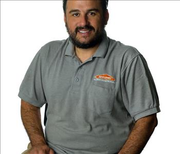 Man in SERVPRO uniform posing for a picture on a white background