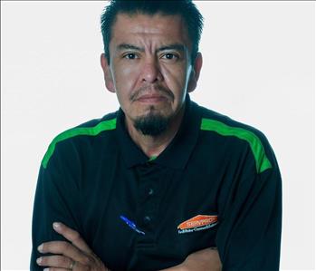 Man in SERVPRO uniform posing for a picture on a white background