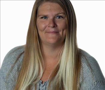 Blonde woman in SERVPRO uniform posing for a picture on a white background