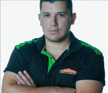 Man in SERVPRO uniform posing for a picture on a white background