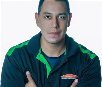 Man in SERVPRO uniform posing for a picture on a white background