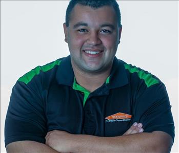 Man in SERVPRO uniform posing for a picture on a white background