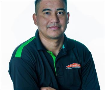 Man in SERVPRO uniform posing for a picture on a white background