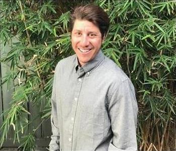 Photo of a man in front of a hedge