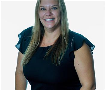 Blonde woman in SERVPRO uniform posing for a picture on a white background