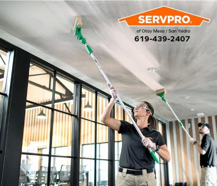 A crew is cleaning a fire-damaged ceiling.