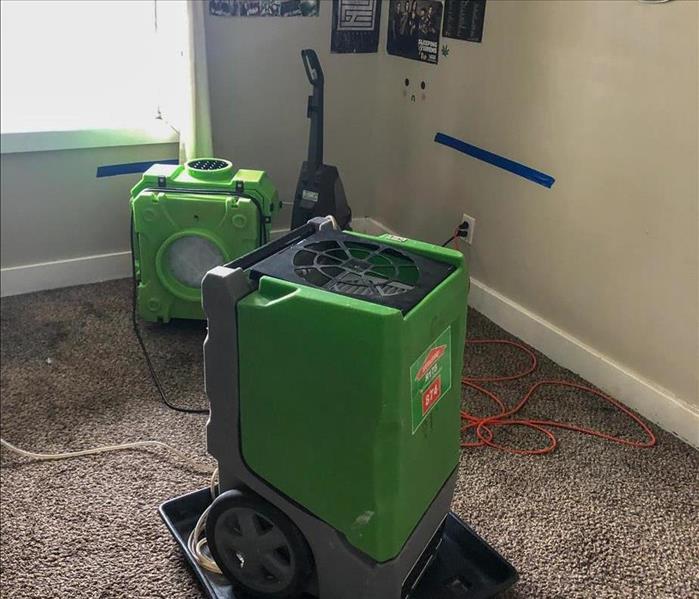 Air movers set up to dry a carpet in a bedroom in a San Ysido, CA home